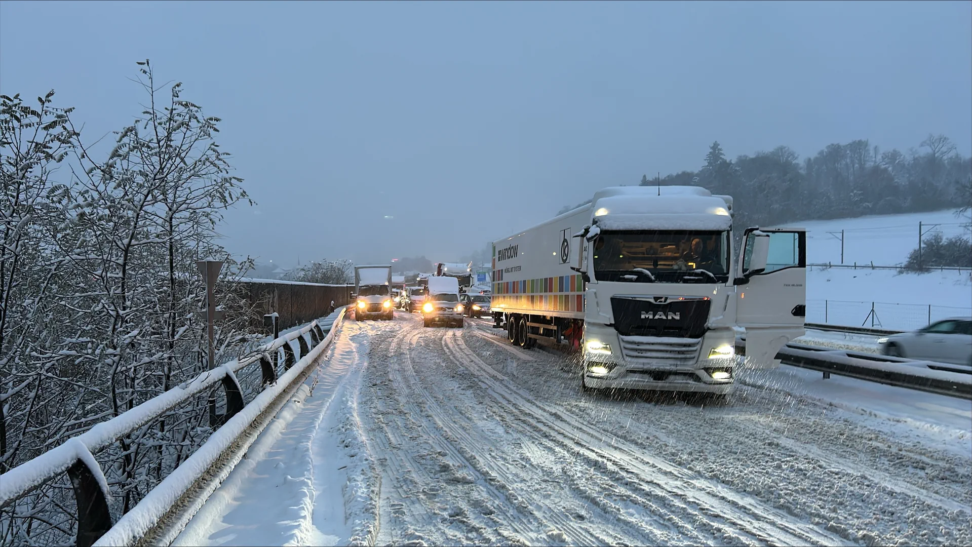 Auf der Autobahn A12 steht ein Lastwagen quer auf der schneebedeckten Fahrbahn - hinten stauen sich die Autos