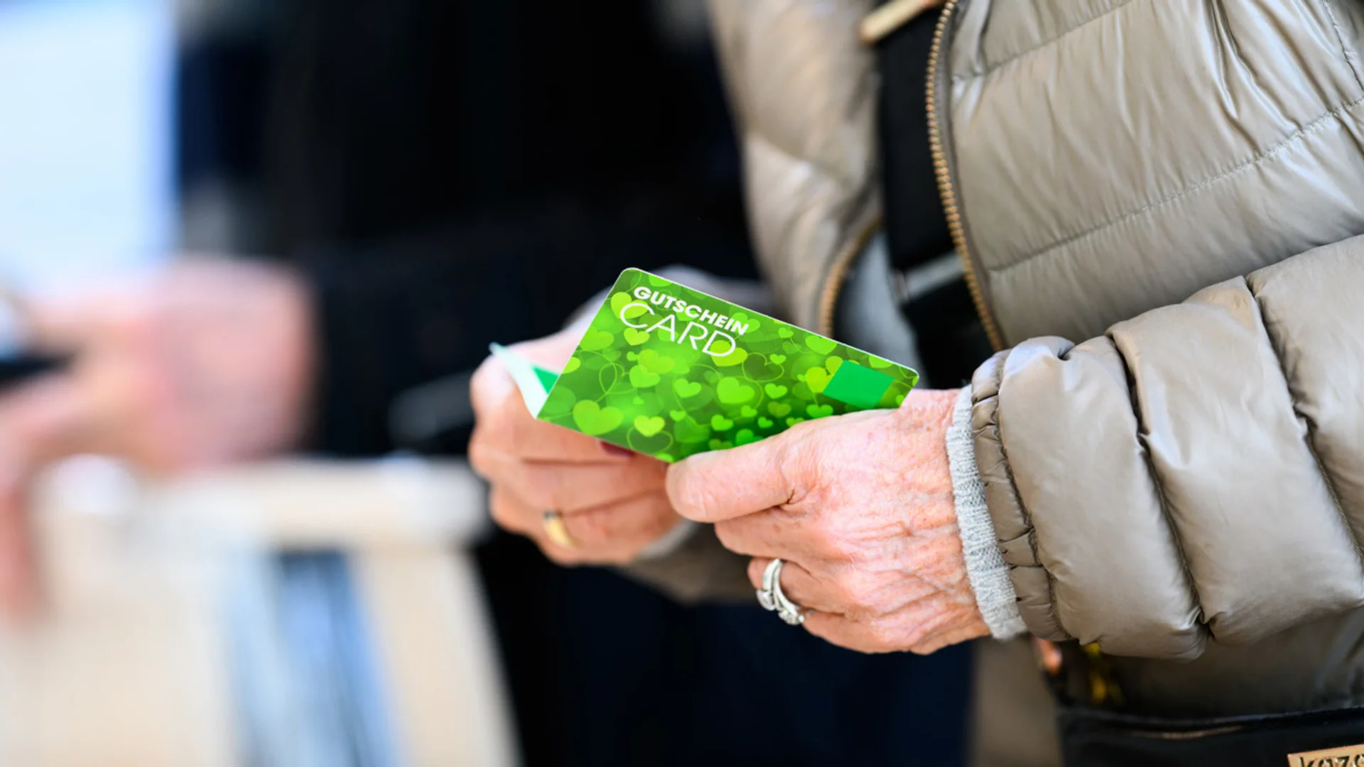 Frau mit einem Geschenkgutschein in der Hand