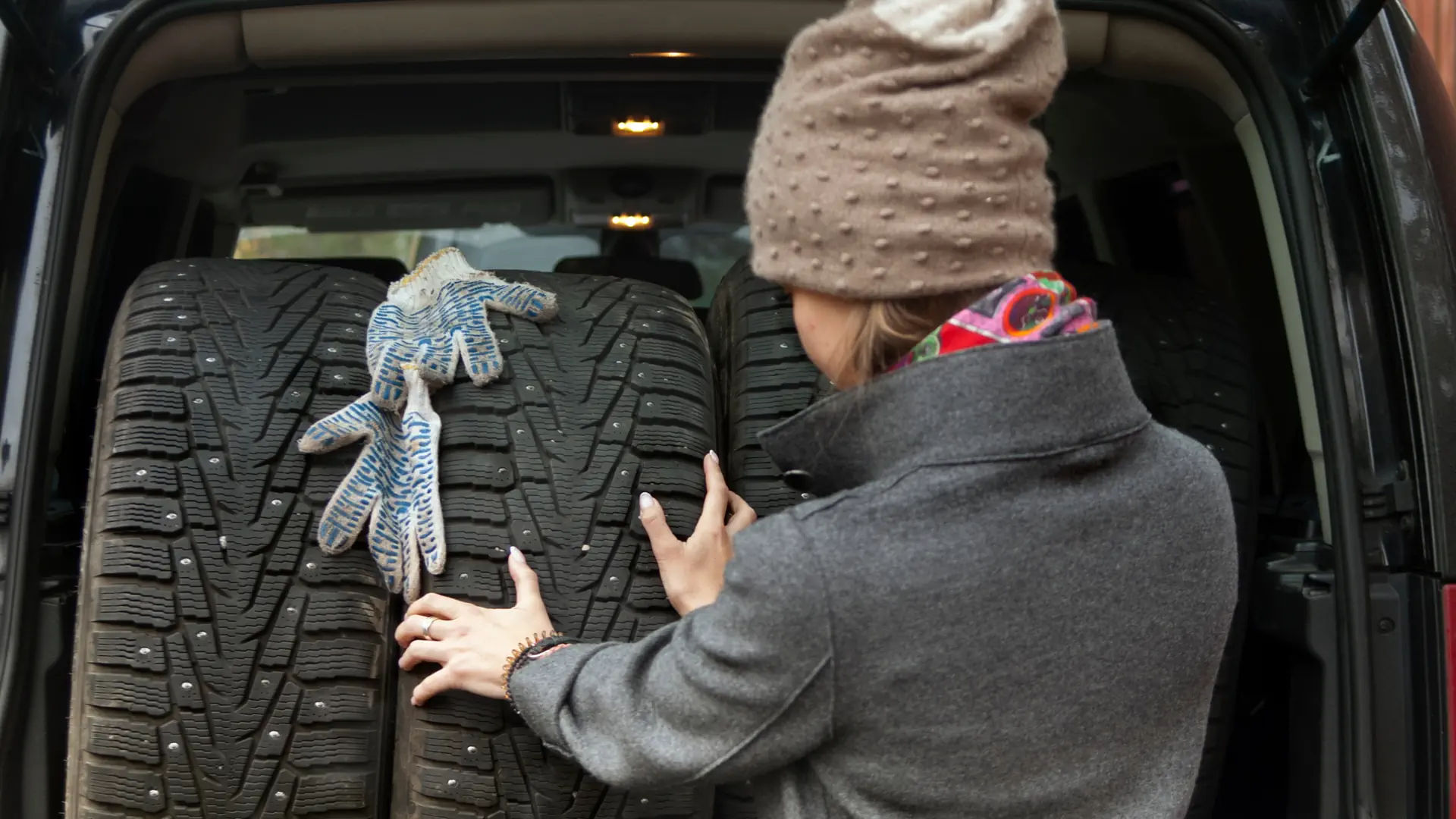 Frau lädt Autoreifen in ihr Auto ein