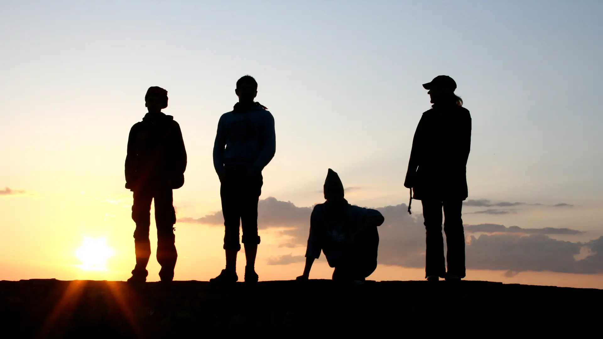 Symbolbild: Vier Männer vor einem Sonnenuntergang