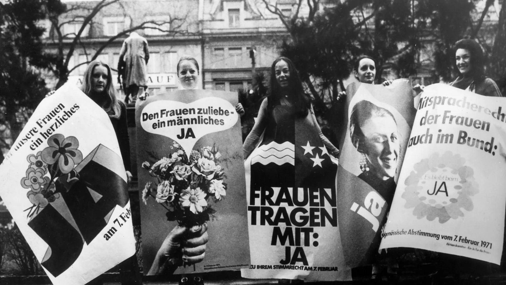 Frauen werben mit entsprechenden Plakaten für das Frauenstimmrecht.