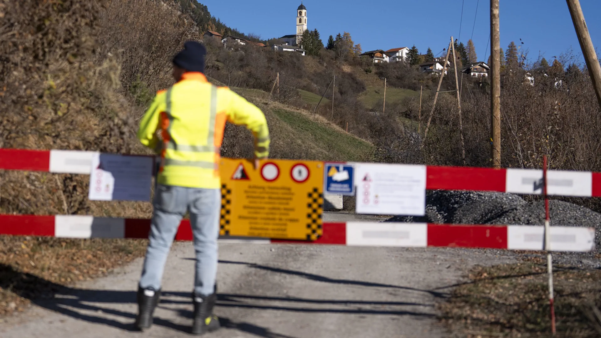 Ein Mann in Leuchtweste sperrt eine Zufahrtsstrasse nach Brienz ab.