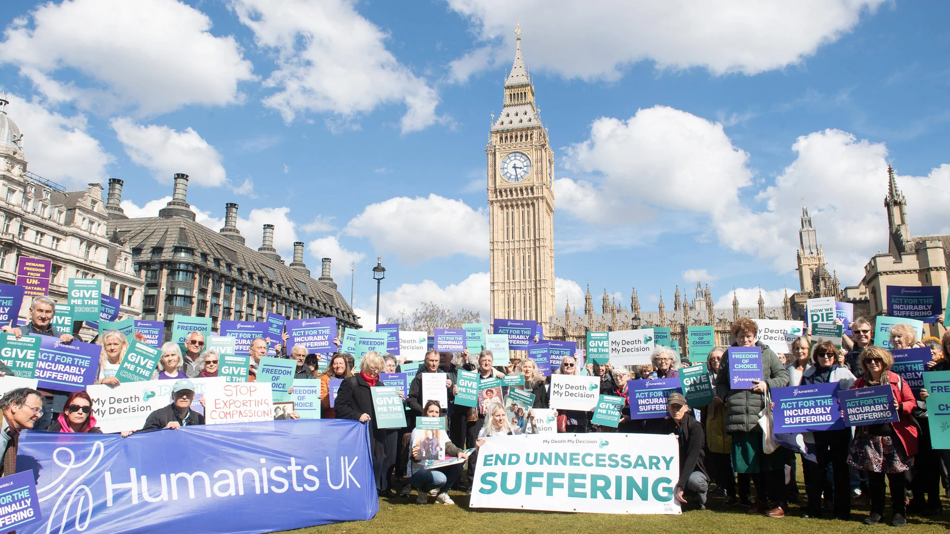 Menschen mit Plakaten und Schildern vor dem Big Ben in London.