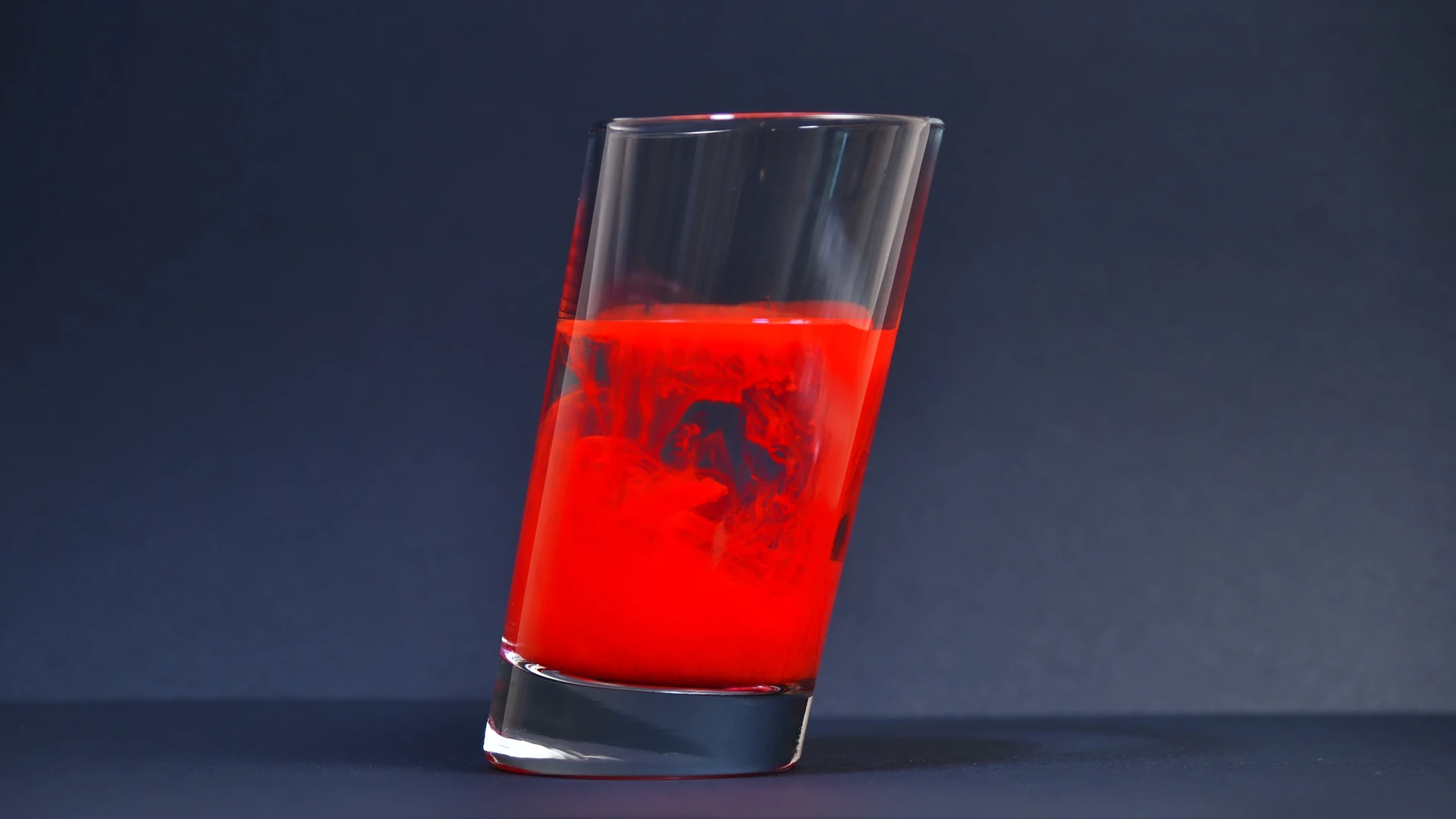 Ein Glas mit Wasser und roter Farbe