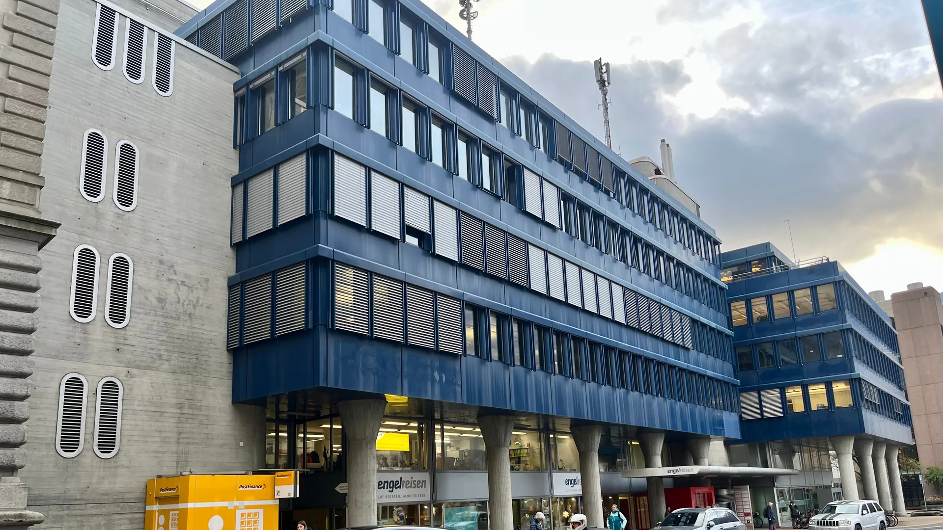 Das Gebäude mit der blauen Metallfassade von Aussen, im Vordergrund Strassenverkehr.