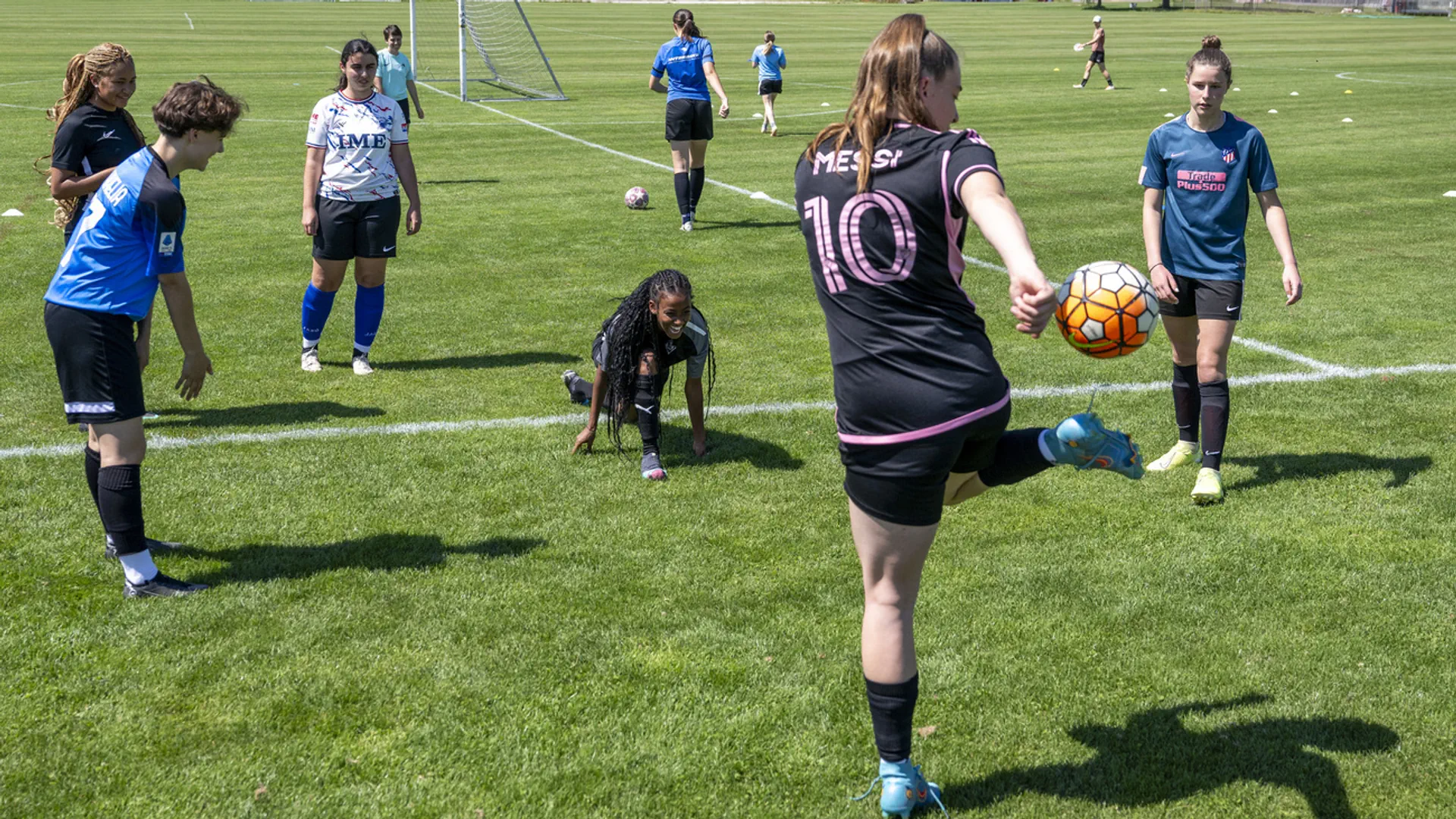 Frauen spielen in einer Gruppe Fussball.